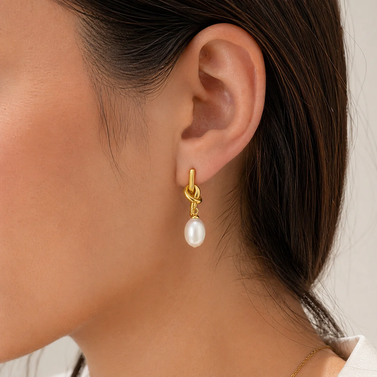 Aretes Acero Dorado Nudo con Perla Ovalada Colgante